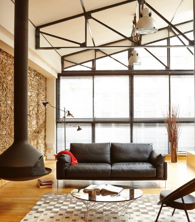 Beaubourg - canapé haut de gamme en cuir noir mis en situation dans un salon avec une cheminée - design et fabrication française par Pascal Daveluy