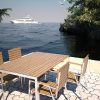Outdoor dining table and chairs in teak and stainless steel